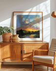 Wooden sideboard with a landscape art print, plant, and chair in a bright room - by Rachel Painter, contemporary artist