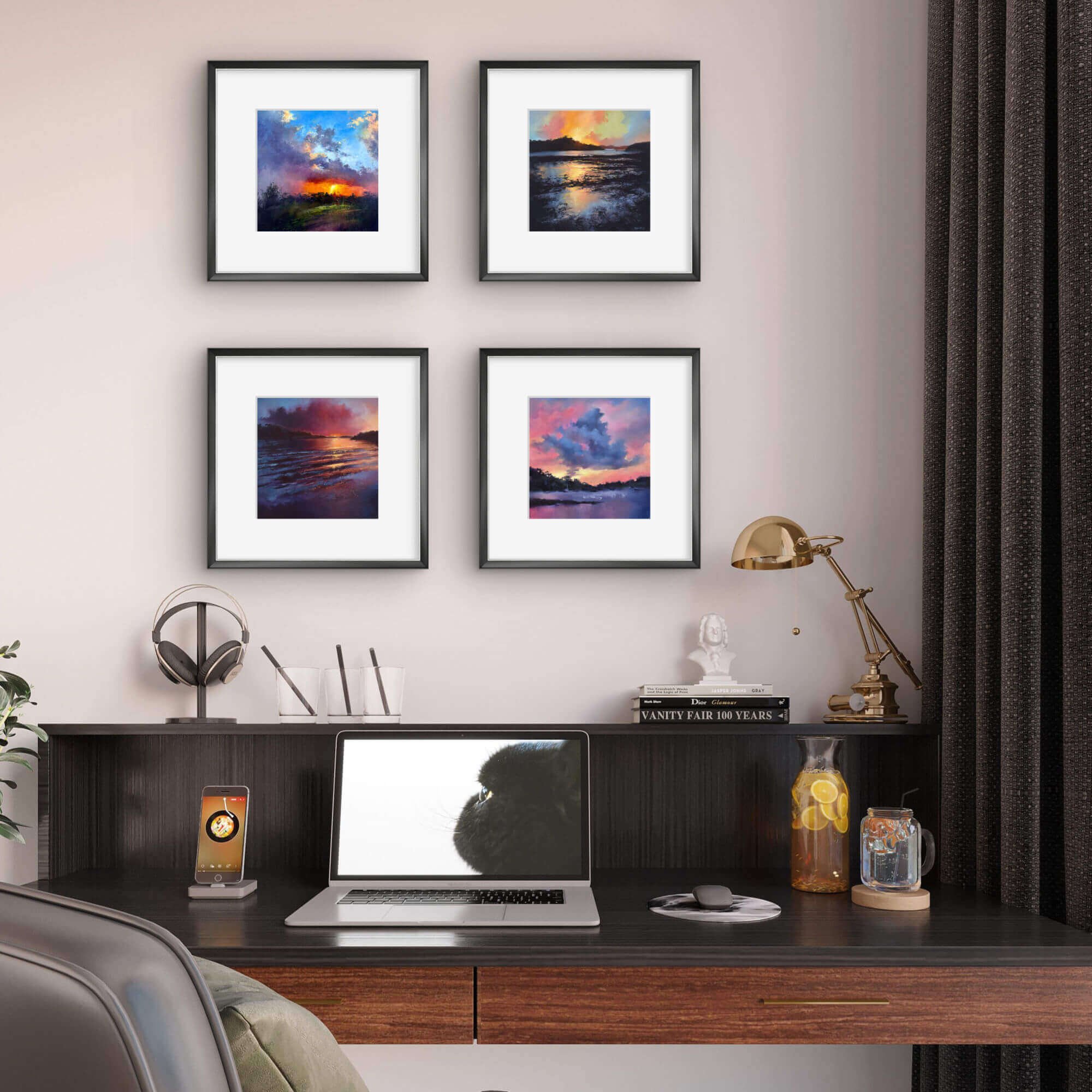 Home office setup with a desk, laptop, and wall art depicting sunset scenes.