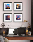 Home office setup with a desk, laptop, and wall art depicting sunset scenes.