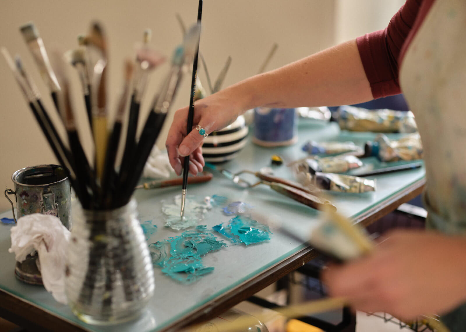 Rachel mixing oil colours on her palette with her paint brush in her artist studio in Cornwall