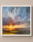 Framed abstract painting of a sunset over a landscape on a warm neutral wall