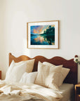 Bedroom with wooden headboard, pillows, and a framed landscape painting on the wall.