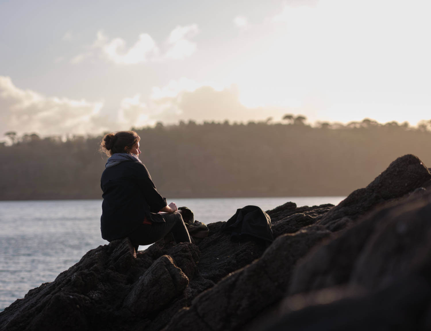 Rachel Painter looking into sunset sketching to capture a sense of awe and wonder to pour into her original landscape oil paintings.