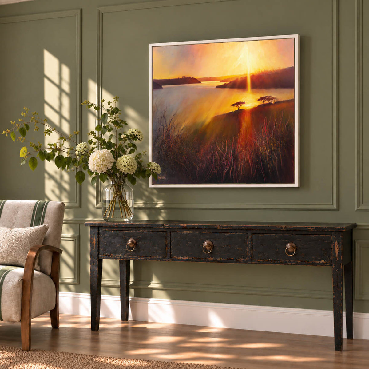 Colourful original sunset landscape painting by Rachel Painter displayed in a light-filled living room with olive green walls.
