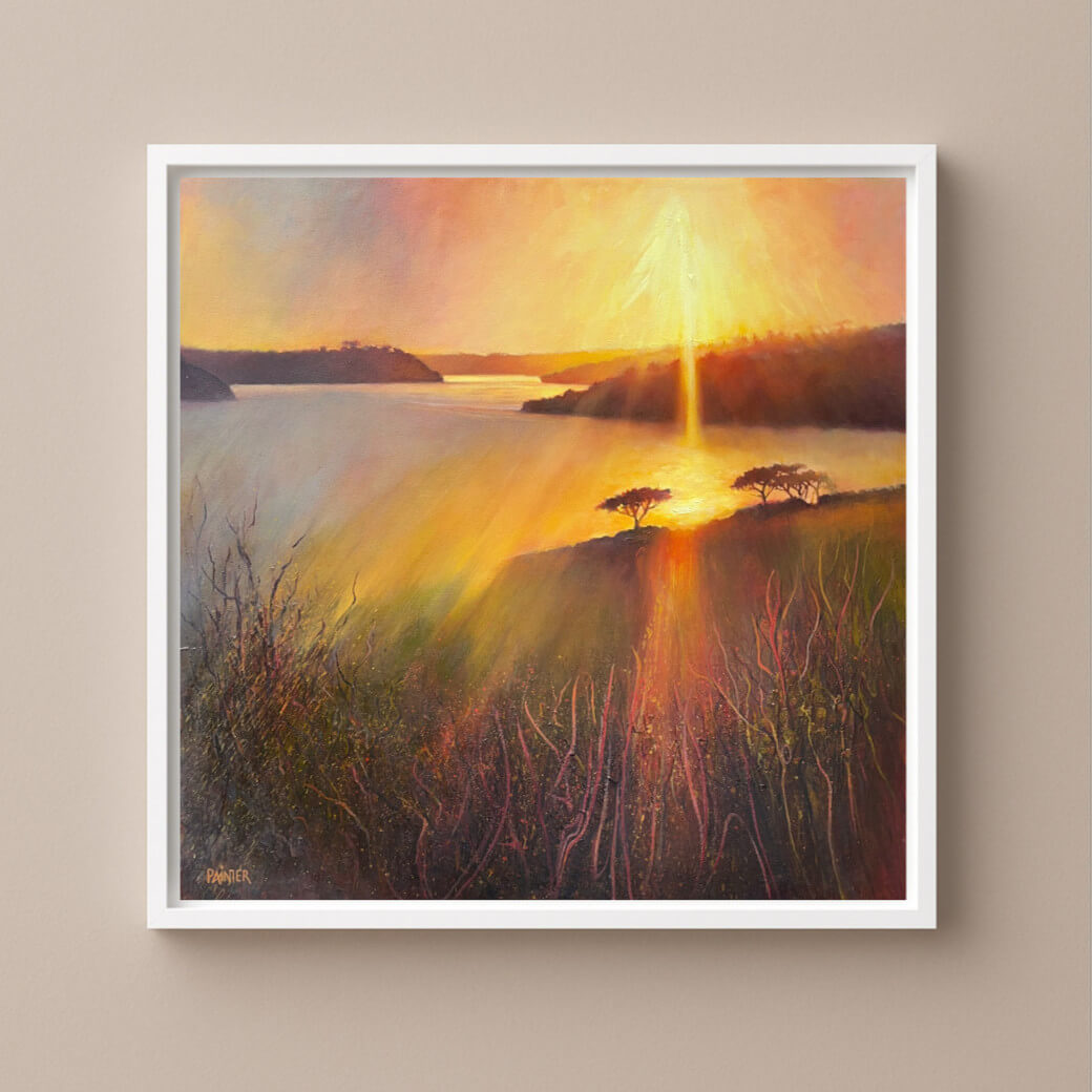 Framed dramatic landscape artwork of a sunset over a river with a white frame on a warm neutral wall. Inspired by the Helford River in Cornwall by Rachel Painter Artist