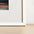 White frame leaning against a white wall with a wooden floor.